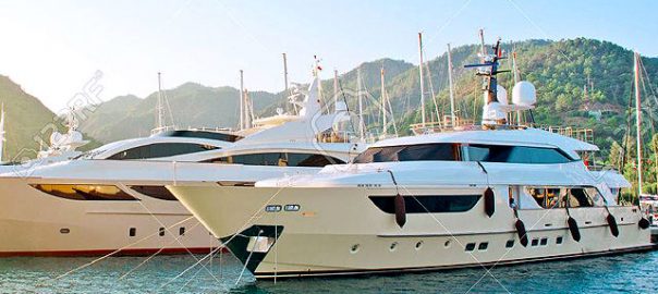 A beautiful yacht parked near the shores with mountains