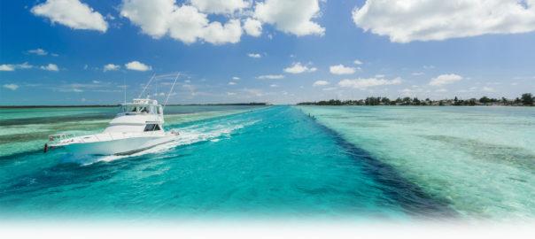 White boat navigating through turquoise waters.