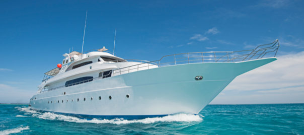 Luxurious yacht sailing on clear blue waters.